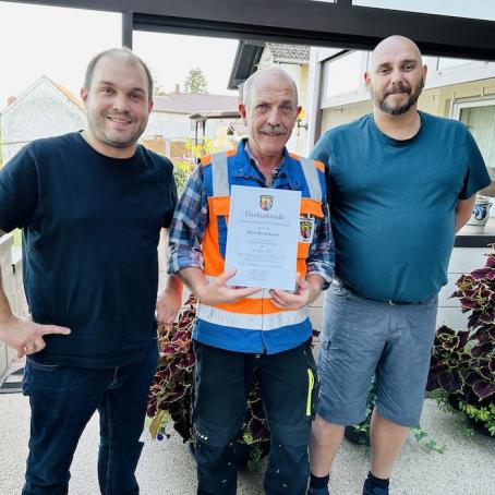 Ortsbürgermeister Tobias Rohrwick (links) und Ortsbeigeordneter Sven Schulz (rechts) gratulieren Bernd Becker (Mitte) zum 25jährigen Dienstjubiläum.