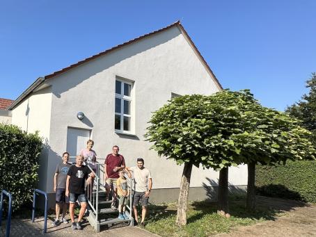 Mitglieder der Ehrenamtsgruppe vor der sanierten und neu gestrichenen Fassade des Bürgerhauses in Flörsheim-Dalsheim.